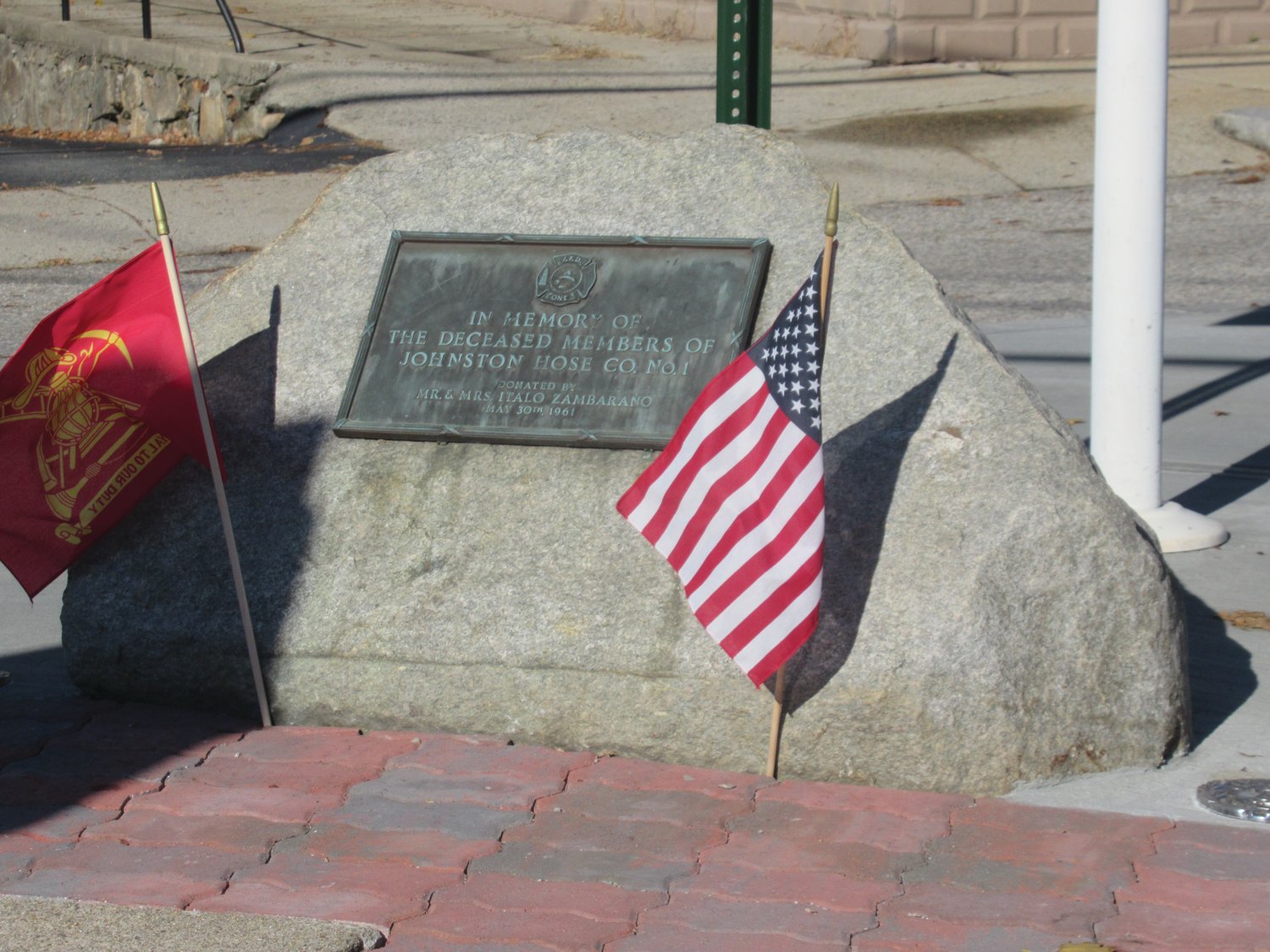 MARVELOUS MEMORIAL: “In memory of all deceased members of Johnston Hose Company No. l are the words inscribed on this ageless plaque that’s surrounded by an American and Firefighter flags and sits at the intersection of Plainfield and School Street in Johnston.
